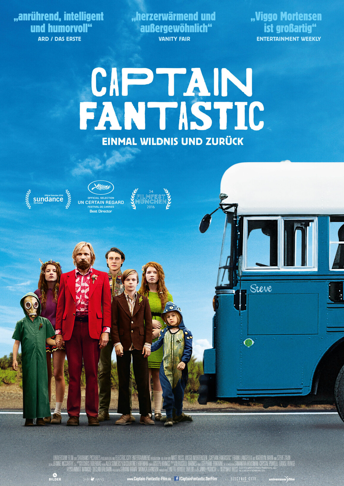 Ein Mann in einem roten Anzug steht umringt von sechs Kindern in verschiedenem Alter neben einem blauen Bus.