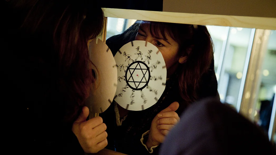 Eine Frau probiert eine Wunderscheibe vor dem Spiegel aus.