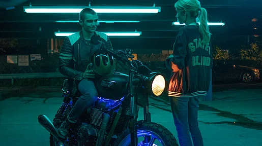 Szenenbild: Vee und Ian in einer Tiefgarage, Ian auf einem Motorrad, Vee steht daneben