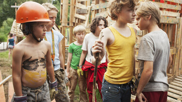 Szenenbild: auf dem Bauplatz rangeln zwei Jungen miteinander