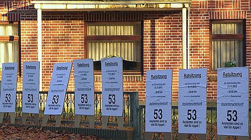 Szenenbild: Plakate an Zaun