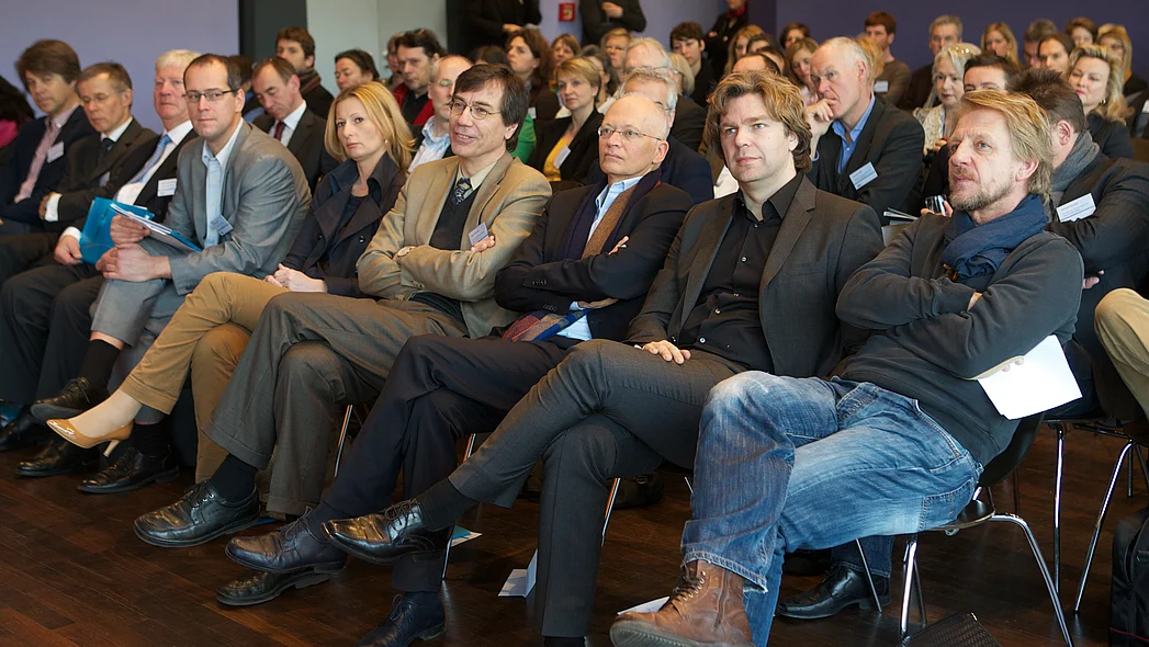 Kongressteilnehmer auf St&uuml;hlen sitzend, darunter S&ouml;nke Wortmann