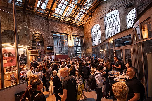 Viele Menschen in einer alten Fabrikhalle - ein Empfang