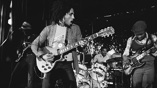 Szenebild: Marley auf der Bühne mit Gitarrre, schwarz-weiß Aufnahme